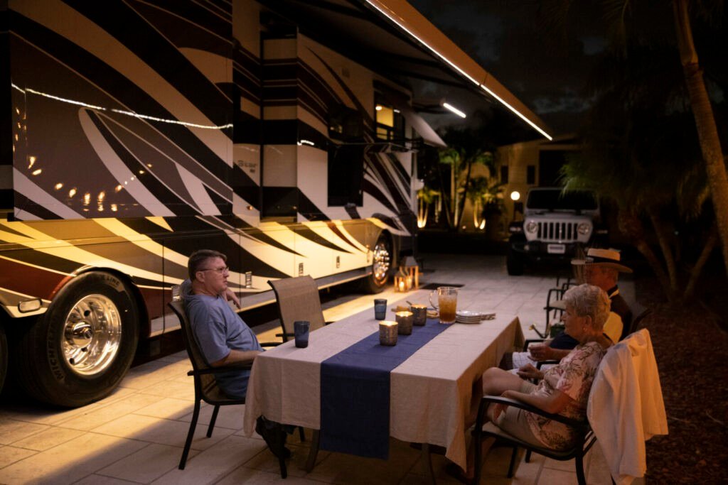 Una pareja disfruta de una cena al aire libre junto a su lujosa casa rodante Newmar