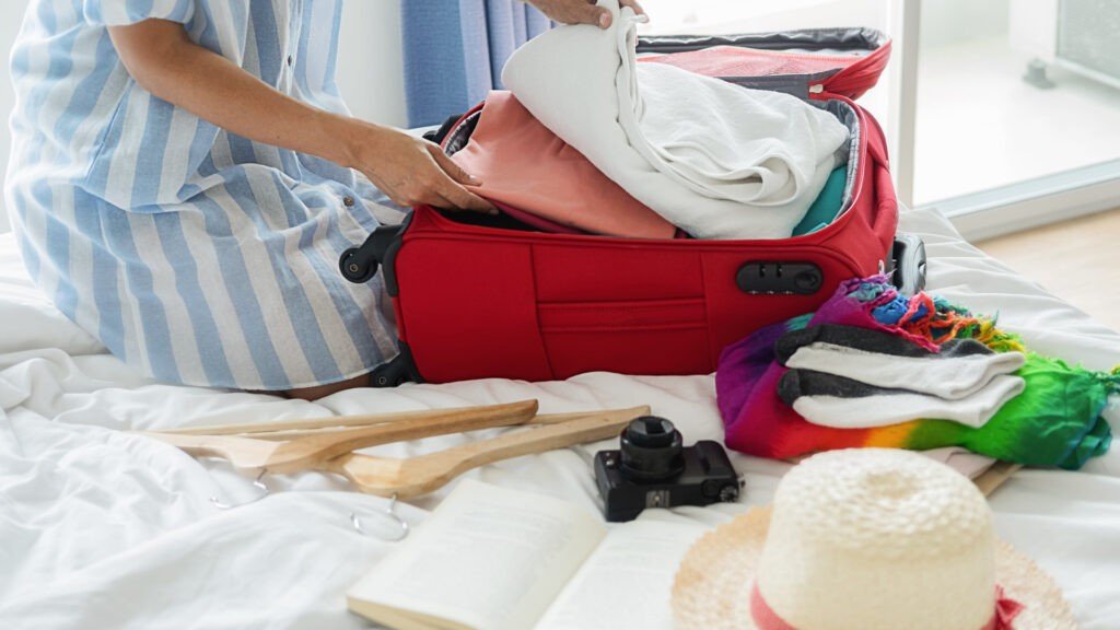 Una mujer empaca sus cosas para sus próximas vacaciones en autocaravana.  Mantiene las cosas organizadas con su lista de verificación de empaque de RV.