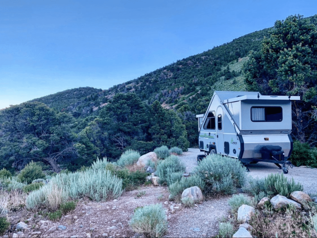 Configuración de la caravana Aliner A-Frame en un pequeño camping en las montañas