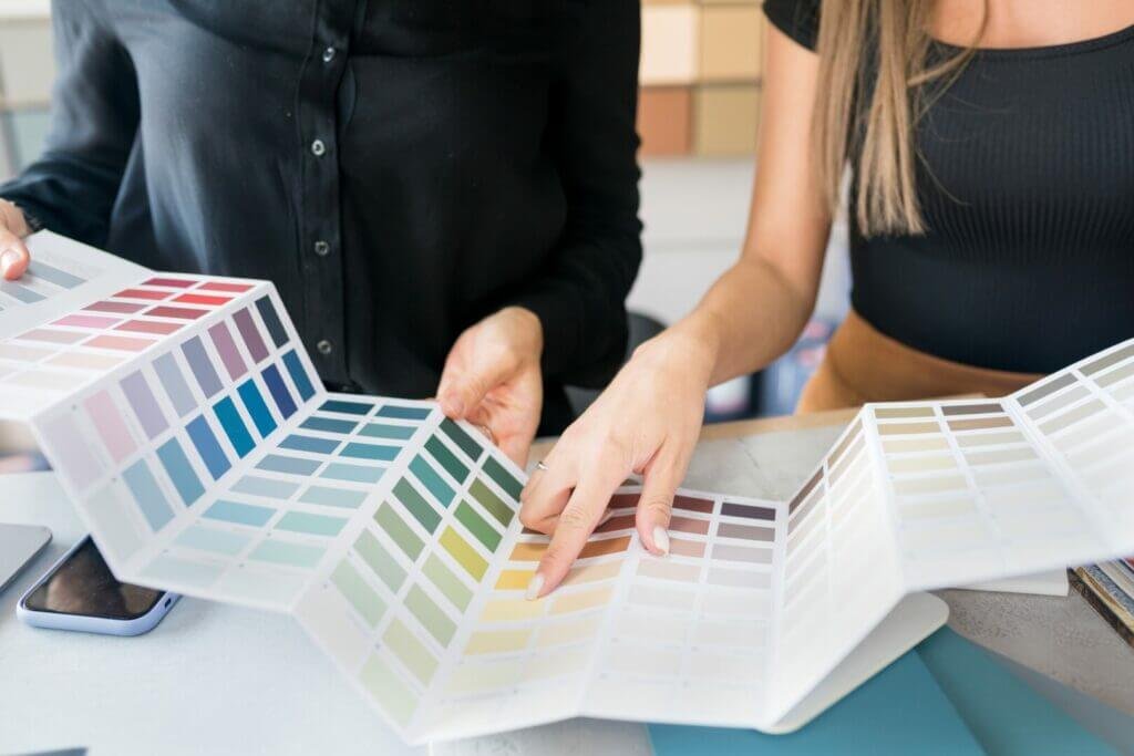 Un hombre y una mujer miran diferentes muestras de colores de pintura.  La pintura es una gran idea única para decorar un RV porque cambia toda la habitación.