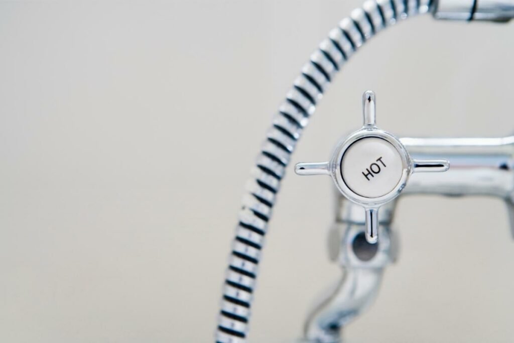 Primer plano de la boquilla de agua caliente en un grifo de ducha