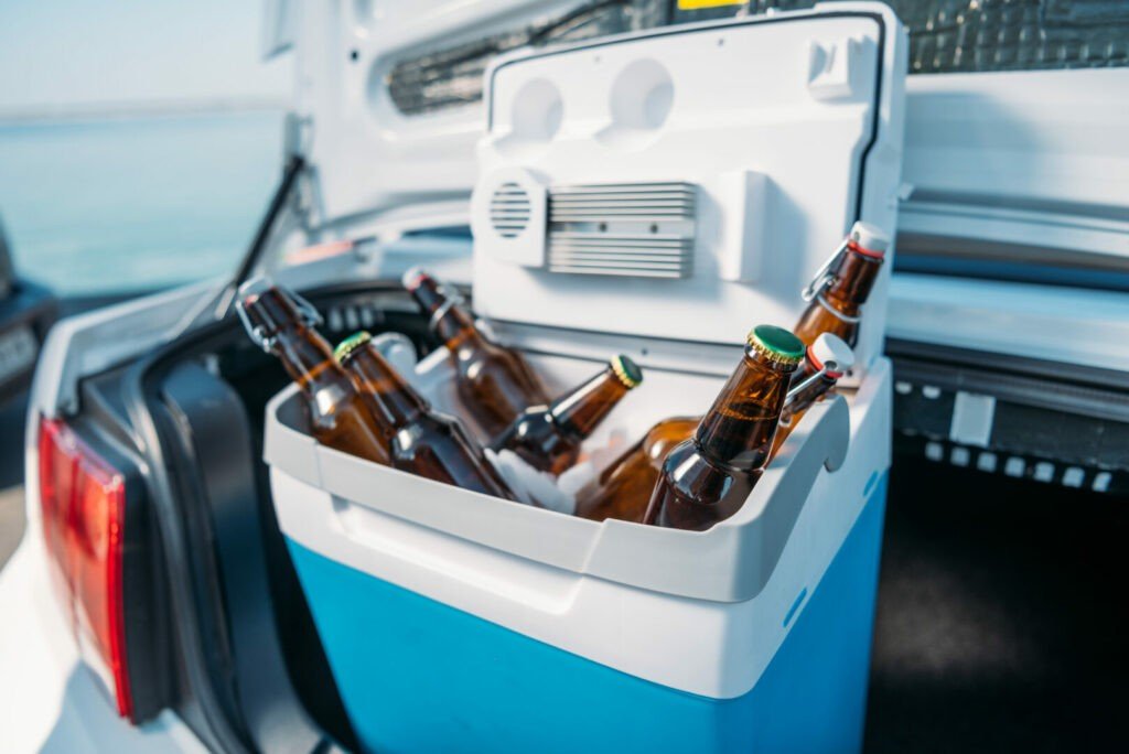 Nevera portátil de 12V con cerveza en el maletero de un coche