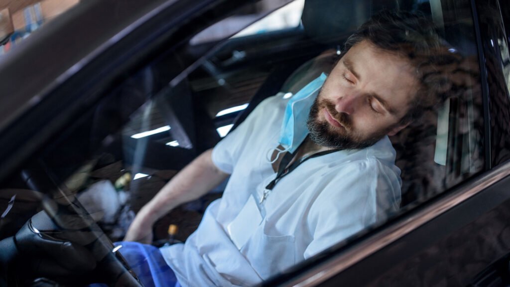 Un hombre duerme en su coche.