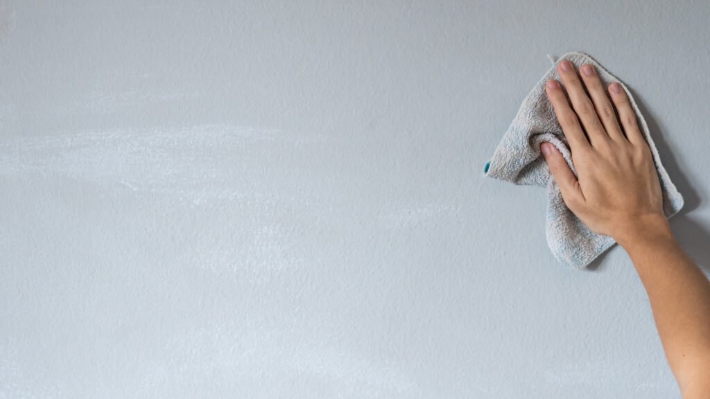 Una persona que limpia su pared antes de aplicar papel tapiz para vehículos recreativos